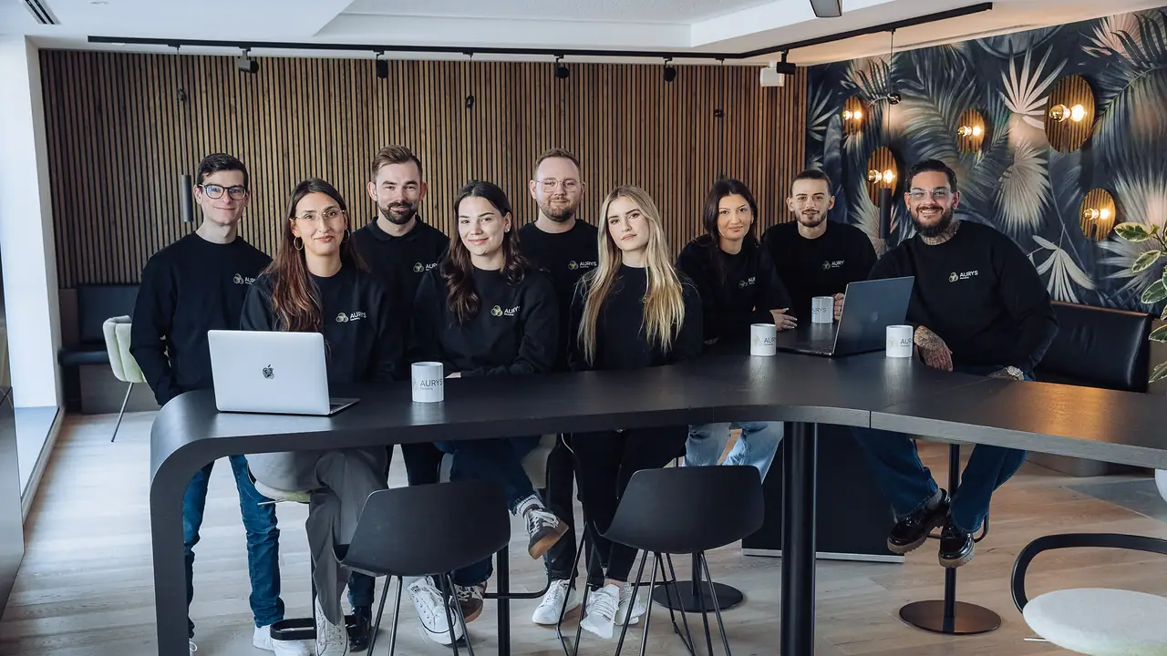 Das AURYS-Team am langen Besprechungstisch im Büro in Grünwald