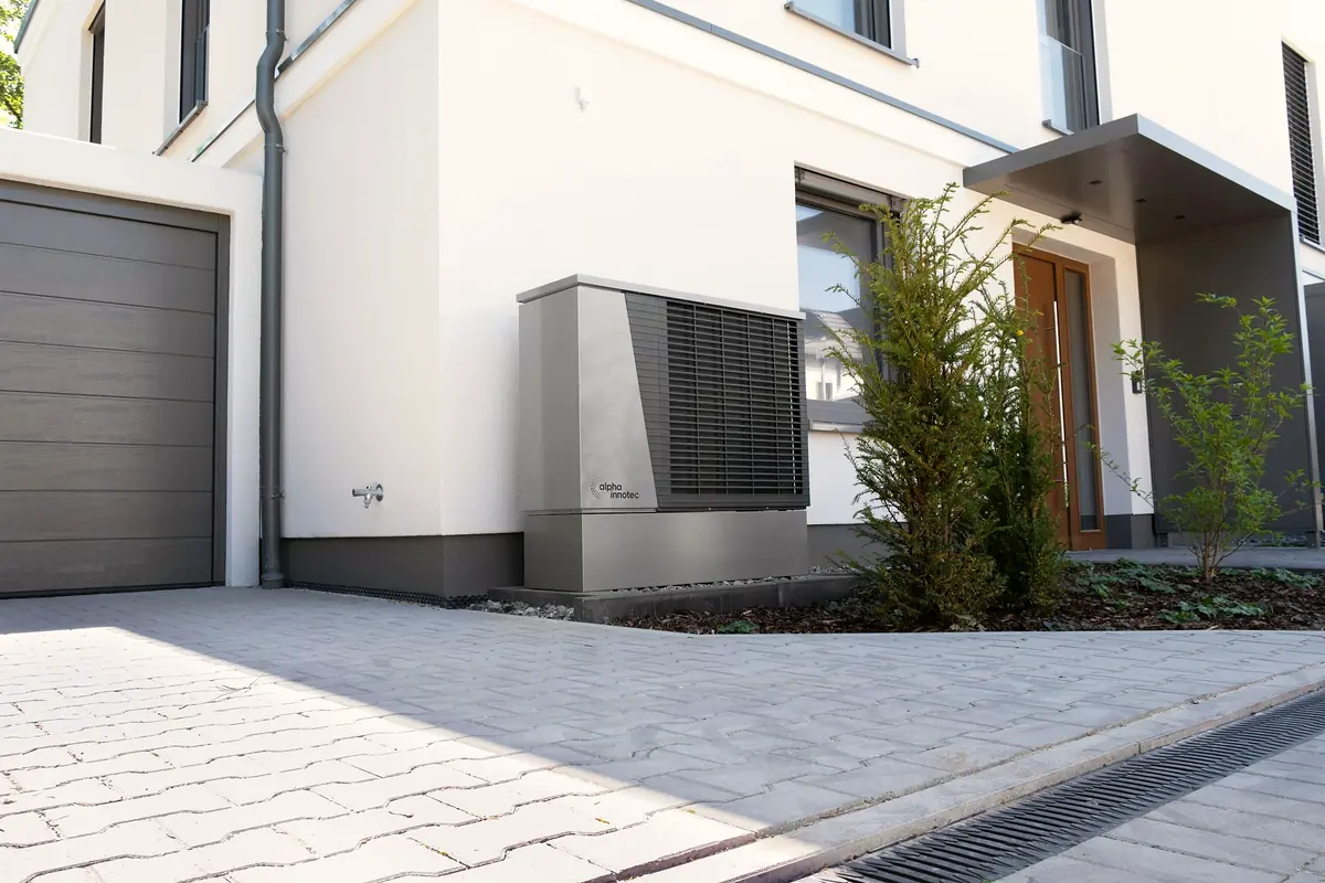 Wärmepumpe vor einem modernen Wohnhaus